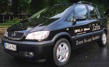 Fotos des Leihfahrzeugs: ein schwarzer Opel Zafira mit Werbeaufklebern des Autohauses Börsch. 